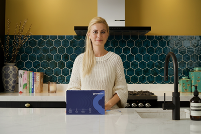 Woman in professional cozy kitchen with Homed-IQ test kit